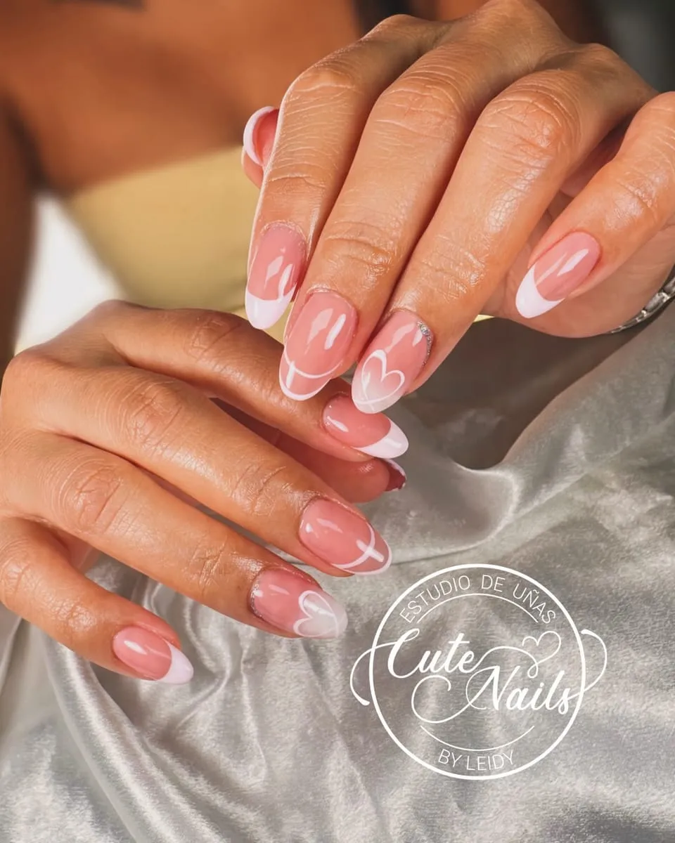 Nude nails with heart-shaped white French tips